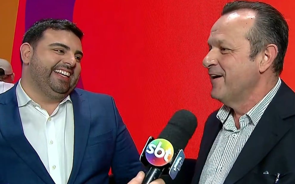 Foto mostra o apresentador Felipe Macedo e o diretor Mauro Lissoni durante coletiva