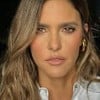 Fernanda Lima usa uma camisa branca e encara a câmera, séria