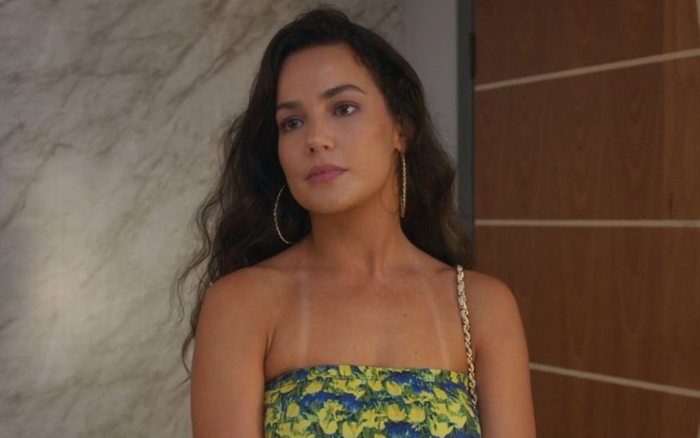 Fernanda Marques está com cabelos soltos e usa blusa sem mangas em cena da novela Beleza Fatal