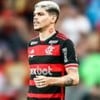 Ayrton Lucas, do Flamengo, veste uniforme listrado em vermelho e preto durante partida da equipe