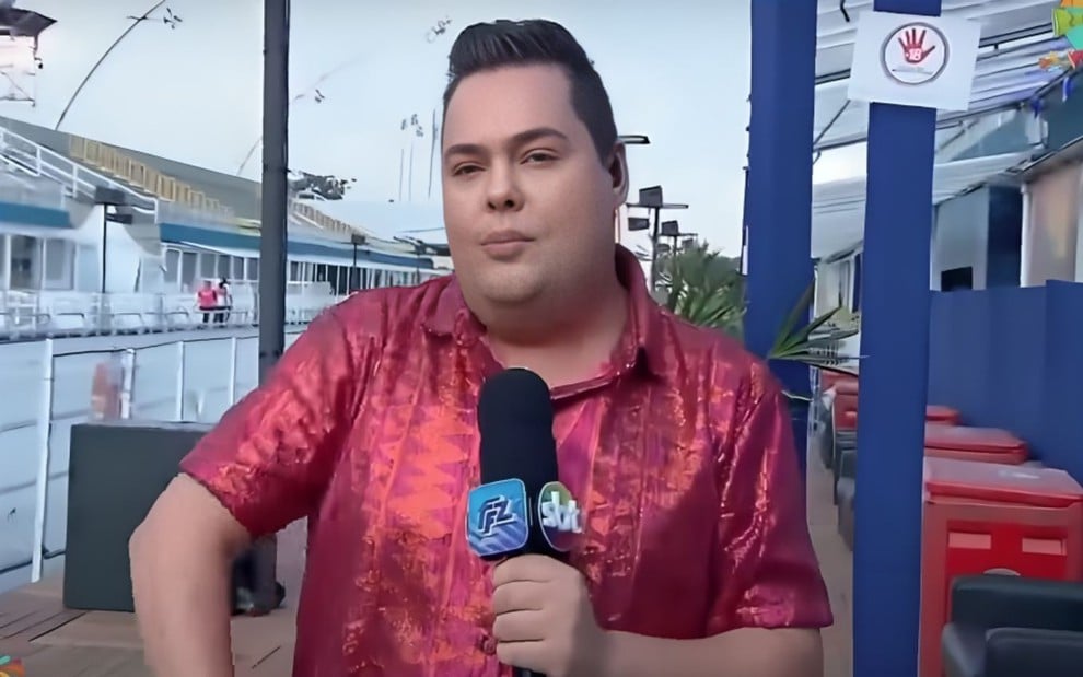 Fofoquito durante cobertura do Carnaval para o Fofocalizando, com microfone na mão, no sambódromo