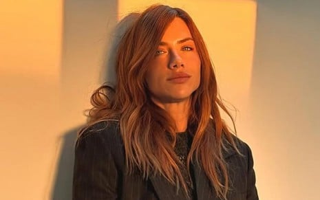 Giovanna Ewbank posando em uma parede branca, em frente ao pôr-do-sol