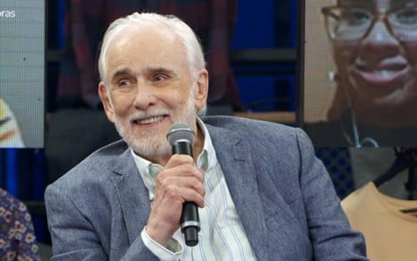Francisco Cuoco sorri discretamente no cenário do Altas Horas