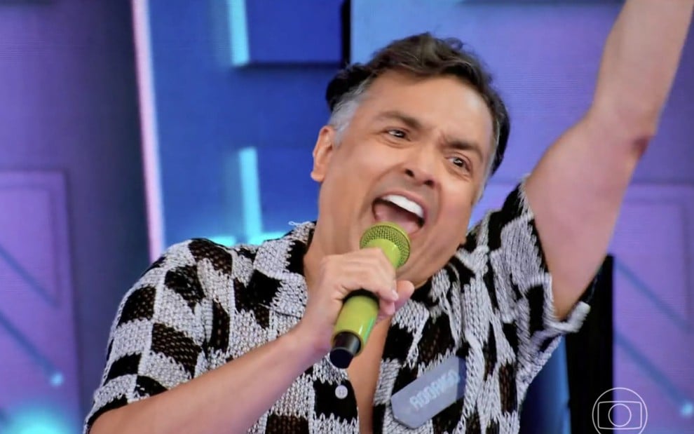 Rodrigo Fagundes ergue o braço e grita, animado, no palco do Caldeirão com Mion