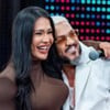 Gracyanne Barbosa e Belo posam sorridentes e abraçados no palco do Domingão