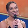 Renata Saldanha sorri forçadamente no palco do Domingão