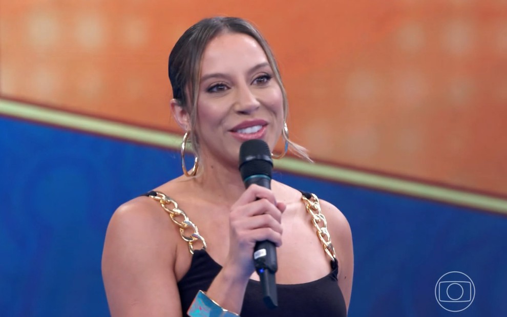 Renata Saldanha sorri forçadamente no palco do Domingão