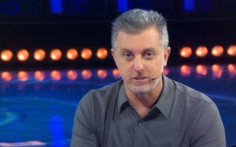 Luciano Huck sentado no cenário do The Wall