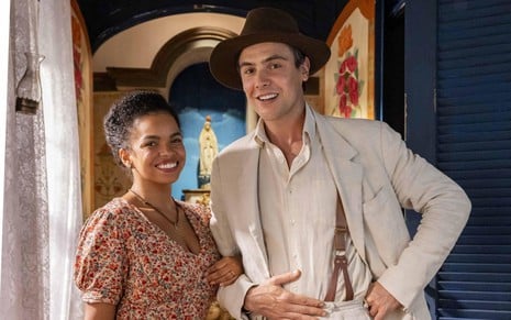 Jeniffer Nascimento e Sergio Guizé posam para foto caracterizados como seus personagens em Êta Mundo Melhor!