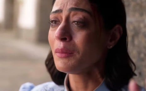 A atriz Carol Castro caracterizada como Clarice, chorando, em cena de Garota do Momento