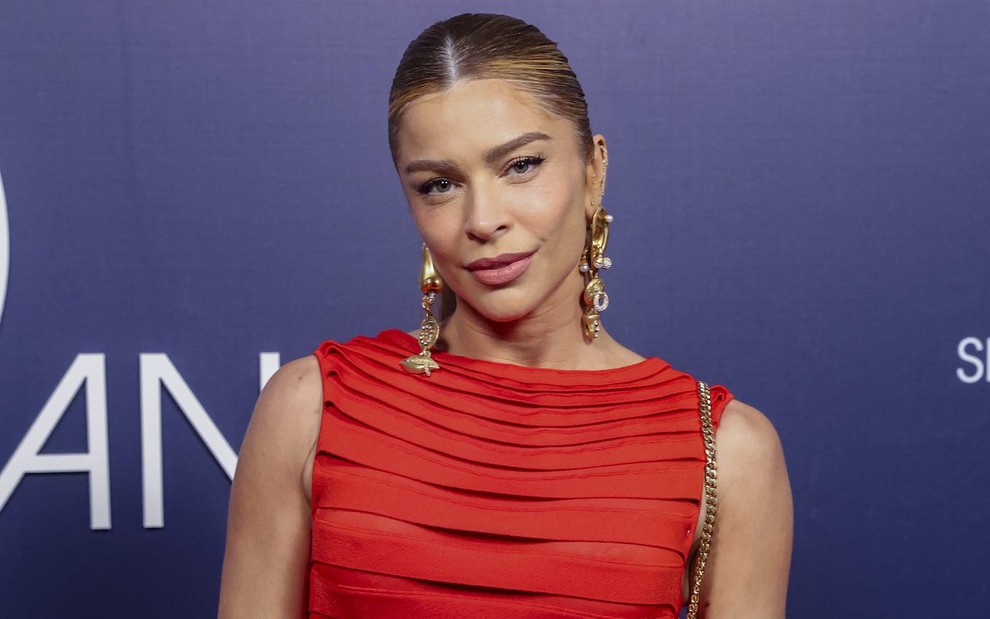 Grazi Massafera posa de vestido vermelho e séria na festa de 60 anos da TV Globo