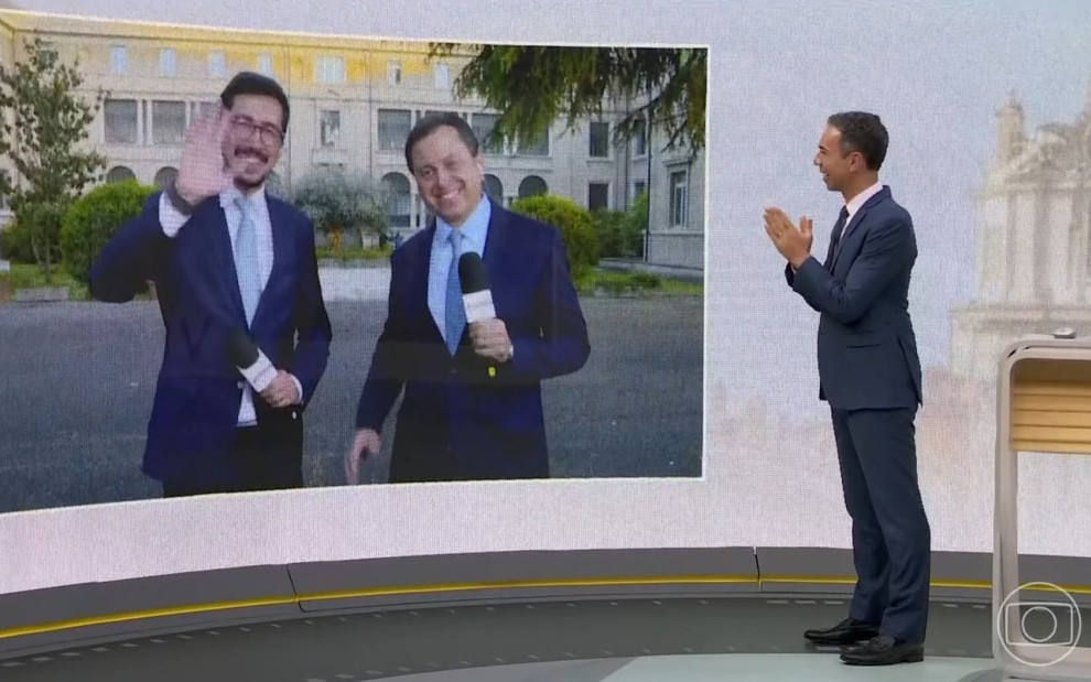 Nilson Klava e Gerson Camarotti acenam no telão do Jornal Hoje para César Tralli, que está no estúdio do noticiário