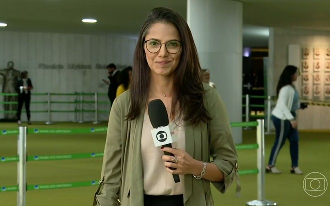 Raquel Honorato posa com microfone da Globo no Congresso Nacional