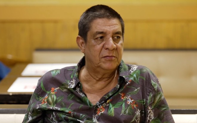 Zeca Pagodinho tem expressão séria em uma mesa de botequim