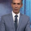 César Tralli está sério na bancada do Jornal Nacional; parte de sua cabeça está cortada para fora da imagem