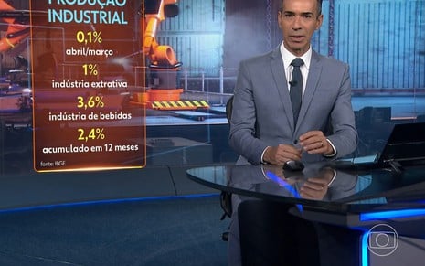 César Tralli está sério na bancada do Jornal Nacional; parte de sua cabeça está cortada para fora da imagem