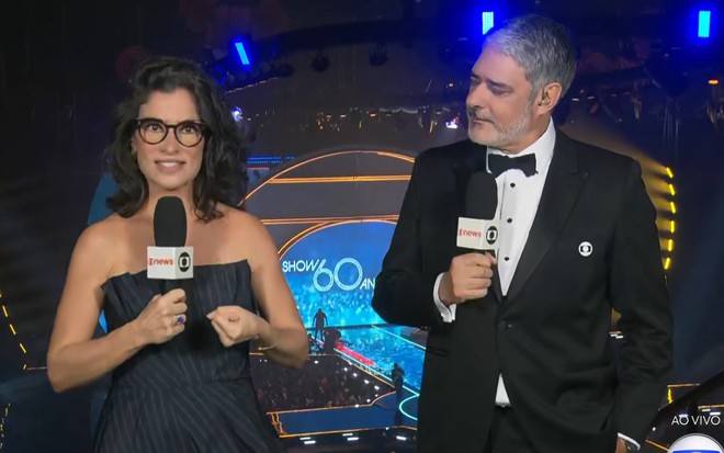 Renata Vasconcellos parece assustada enquanto é observada por William Bonner em uma arena de shows