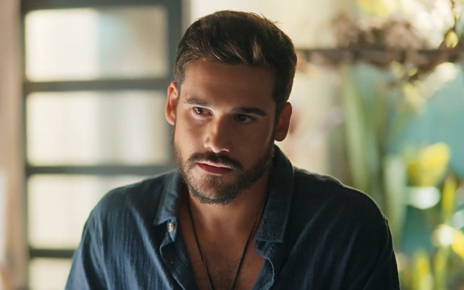 Nicolas Prattes com expressão séria em cena da novela Mania de Você