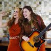 Lorena Comprato como Gláucia e Alice Wegmann como Raíssa cantando em cena de Rensga Hits!