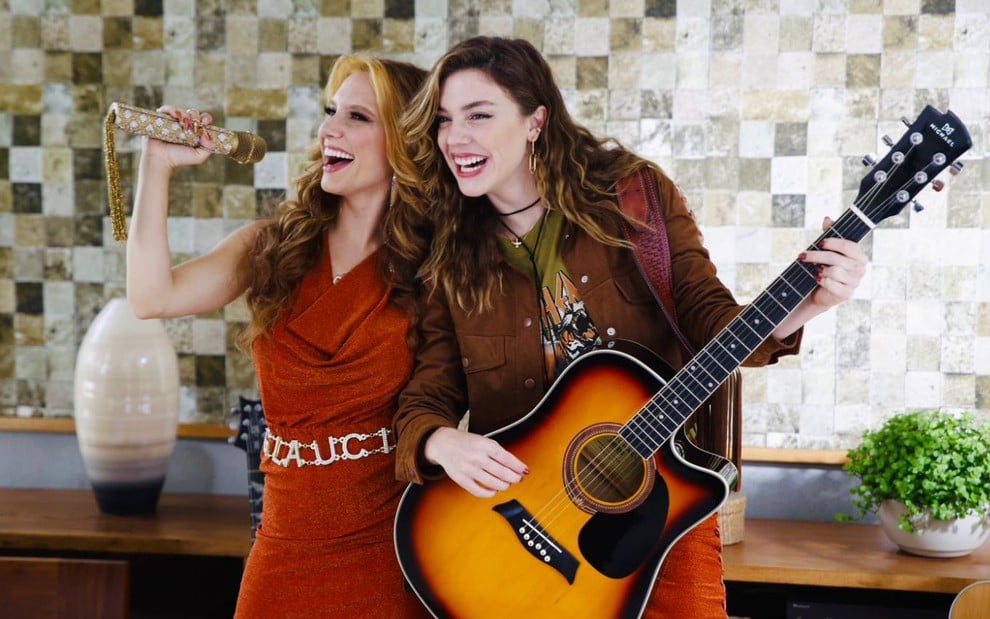 Lorena Comprato como Gláucia e Alice Wegmann como Raíssa cantando em cena de Rensga Hits!