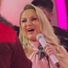 Eliana canta com vestido rosa; Belo, de costas, também canta com ela