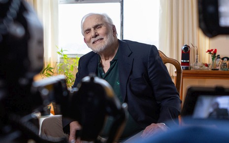 Francisco Cuoco grava entrevista na sala de sua casa