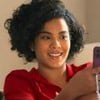 A atriz Bella Campos segura um Iphone como a Maria de Fátima em cena de Vale Tudo