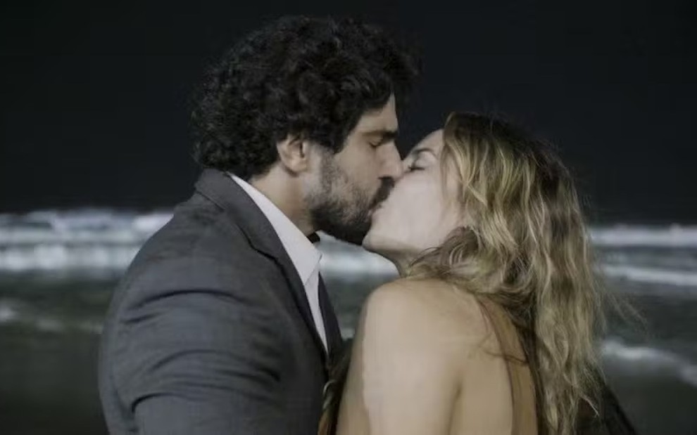 Renato Góes grava cena de beijo com Paolla Oliveira em uma praia para o remake de Vale Tudo, da Globo