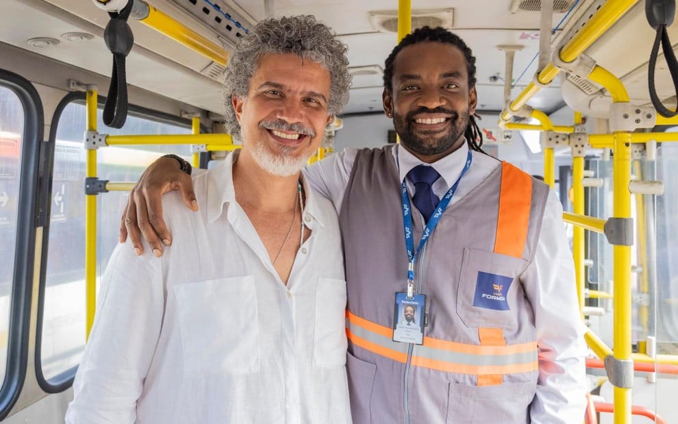 André Câmara abraça Fabrício Boliveira, o Jão; os dois estão dentro de um ônibus nos bastidores de Volta por Cima