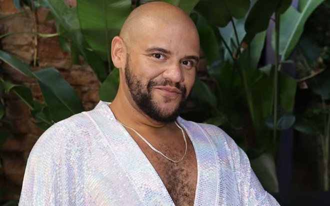 Foto mostra Gominho vestido com macacão branco