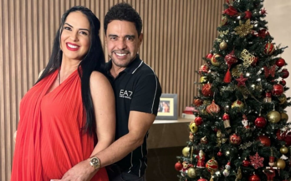 Graciele Lacerda e Zezé Di Camargo posam em frente a uma árvore Natal