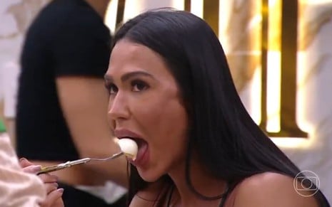 Gracyanne Barbosa abre a boca para comer um ovo cozido