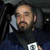 Montagem de Guilherme Pimentel no banco do passageiro do carro; ele segura o microfone da Globo na mão