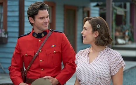 Kevin McGarry e Erin Krakow posam sorridentes com os figurinos de Quando Chama o Coração