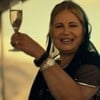 Jennifer Coolidge ergue uma taça de champanhe em cena da série The White Lotus