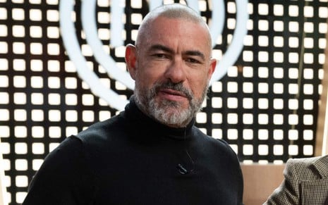 O chef de cozinha e jurado do MasterChef Brasil Henrique Fogaça no estúdio do programa, com expressão séria