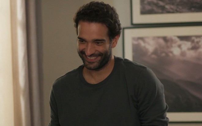 Humberto Carrão sorri em cena da novela Vale Tudo