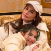 Deborah Secco abraça a filha, Maria Flor, no sofá de um hotel