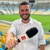 Fernando Campos segura microfone da ESPN em um estádio vazio de futebol
