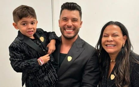 Murilo Huff segura o filho no colo e posa sorridente ao lado da ex-sogra, dona Ruth Moreira