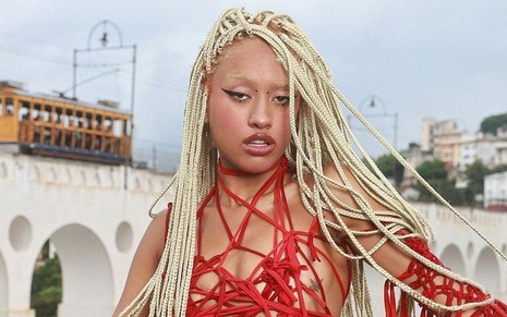 Muse Maya posa para foto nos Arcos da Lapa, no Rio de Janeiro, com um look vermelho