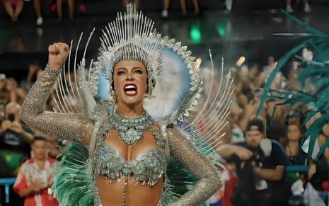 Paolla Oliveira vestida com a fantasia de seu último desfile na Grande Rio; fantasia é prata e azul, com leds azuis