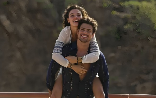 Cauã Reymond e Ísis Valverde em Amores Roubados (2014); ela está apoiada nas costas dele, enquanto os dois aparecem sorridentes