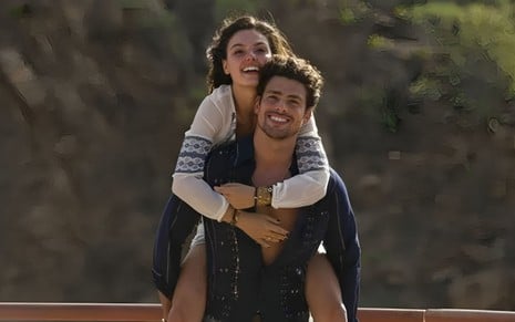 Cauã Reymond e Ísis Valverde em Amores Roubados (2014); ela está apoiada nas costas dele, enquanto os dois aparecem sorridentes