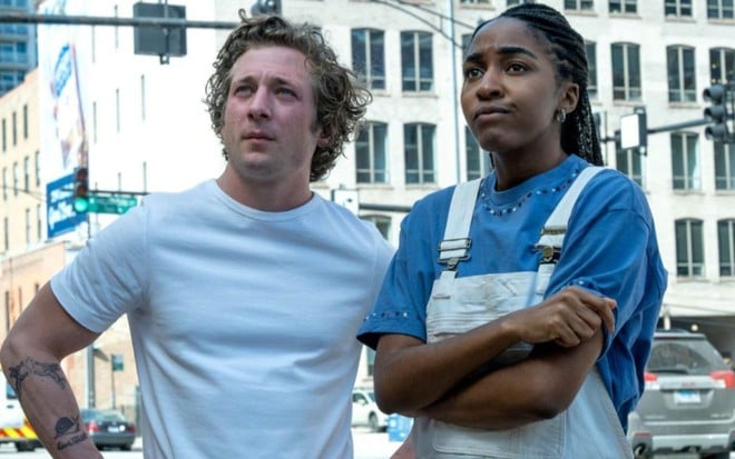 Jeremy Allen White e Ayo Edebiri em cena de The Bear, ambos olham para a frente com indignação e usam roupas azuis