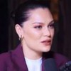 Jessie J no podcast The Diary of a CEO; ela usa blazer roxo em fundo escuro