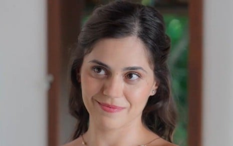 Jessika Alves está com cabelo meio preso e sorri em cena de A Vida Secreta do Meu Marido Bilionário