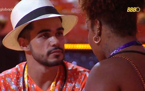 João Pedro Siqueira em papo com Camilla Maia no BBB 25; líder usa chapéu branco e Camilla está de costas