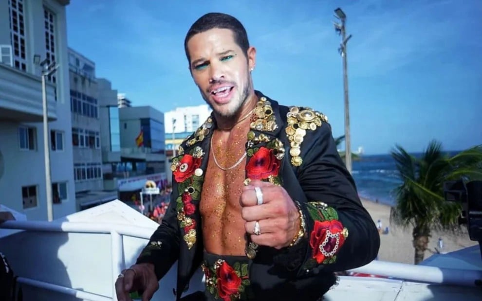 José Loreto caracterizado como Lui Lorenzo, segurando uma rosa vermelha nas mãos