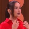 Juliette Freire em sua estreia no Saia Justa; ela está sentada no sofá, de camisa vermelha, com expressão de medo